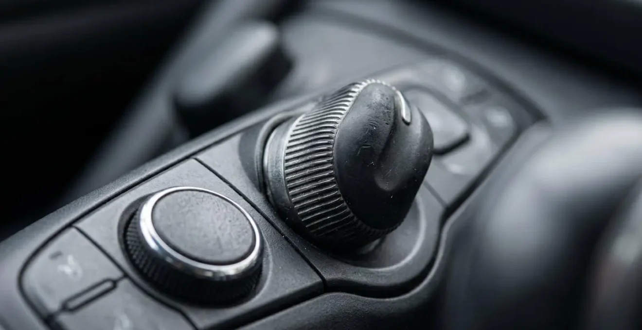 Vue macro sur boutons physiques de climatisation avec texture et relief visibles
