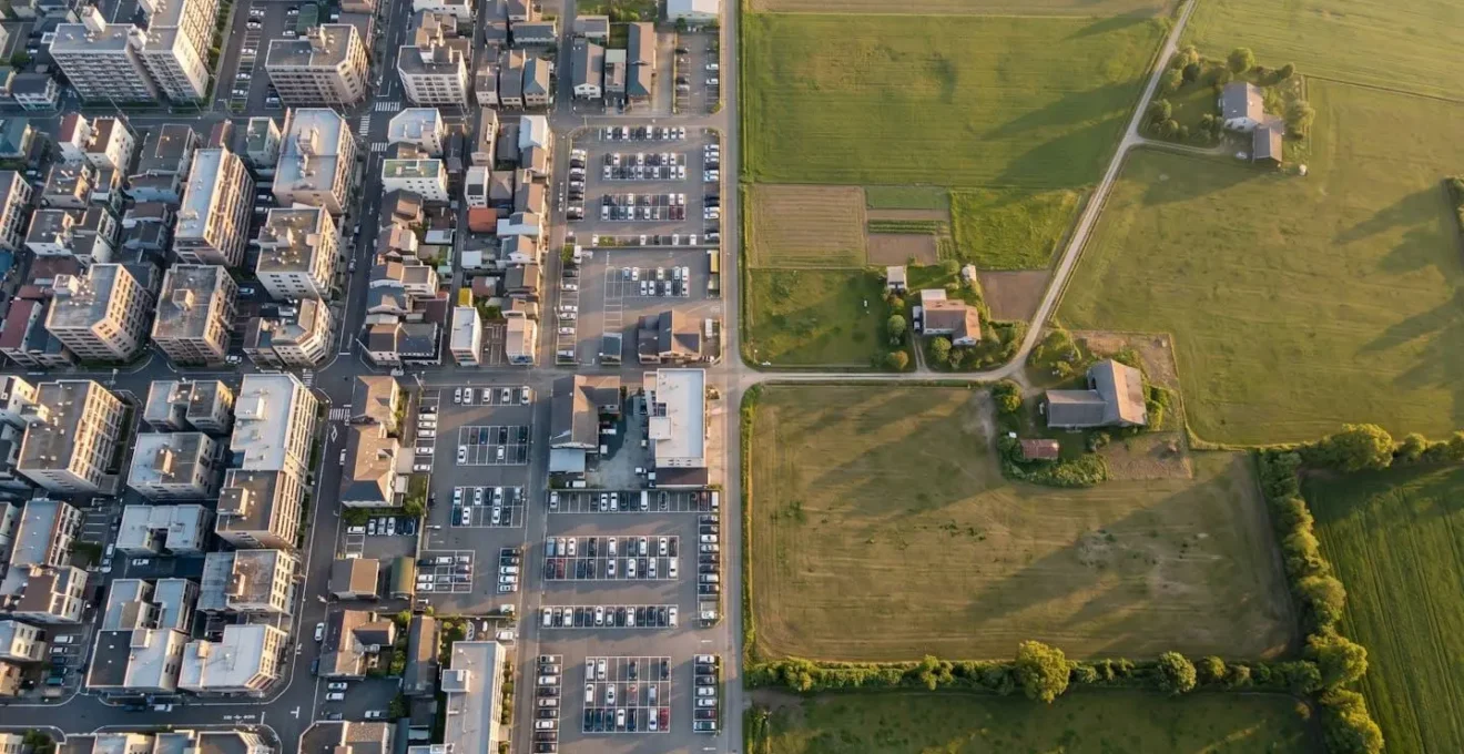 Vue aérienne minimaliste montrant la transition entre zone urbaine dense et campagne française