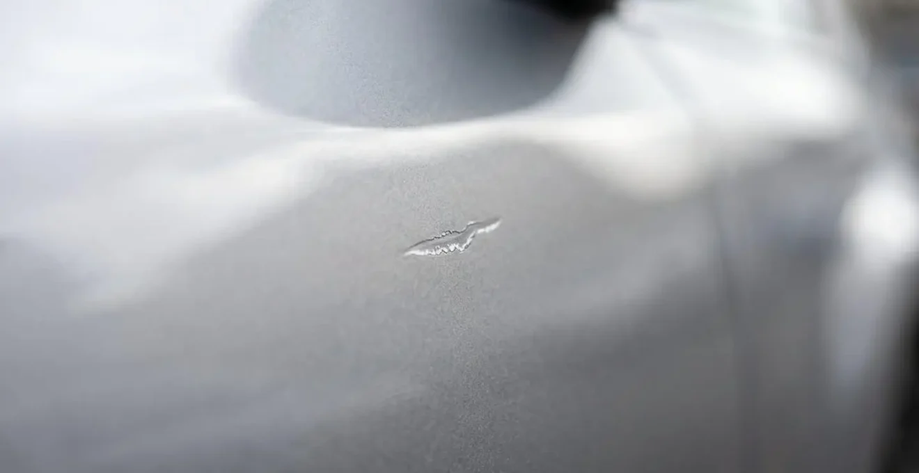 Photo macro montrant une petite rayure sur la carrosserie d'une voiture pour illustrer la transparence