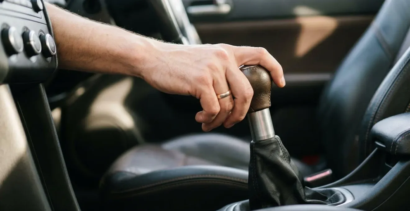 Main d'un conducteur sur le levier de vitesse en position de changement de rapport